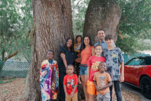 Dos familias se reúnen frente a dos enormes troncos de árboles.