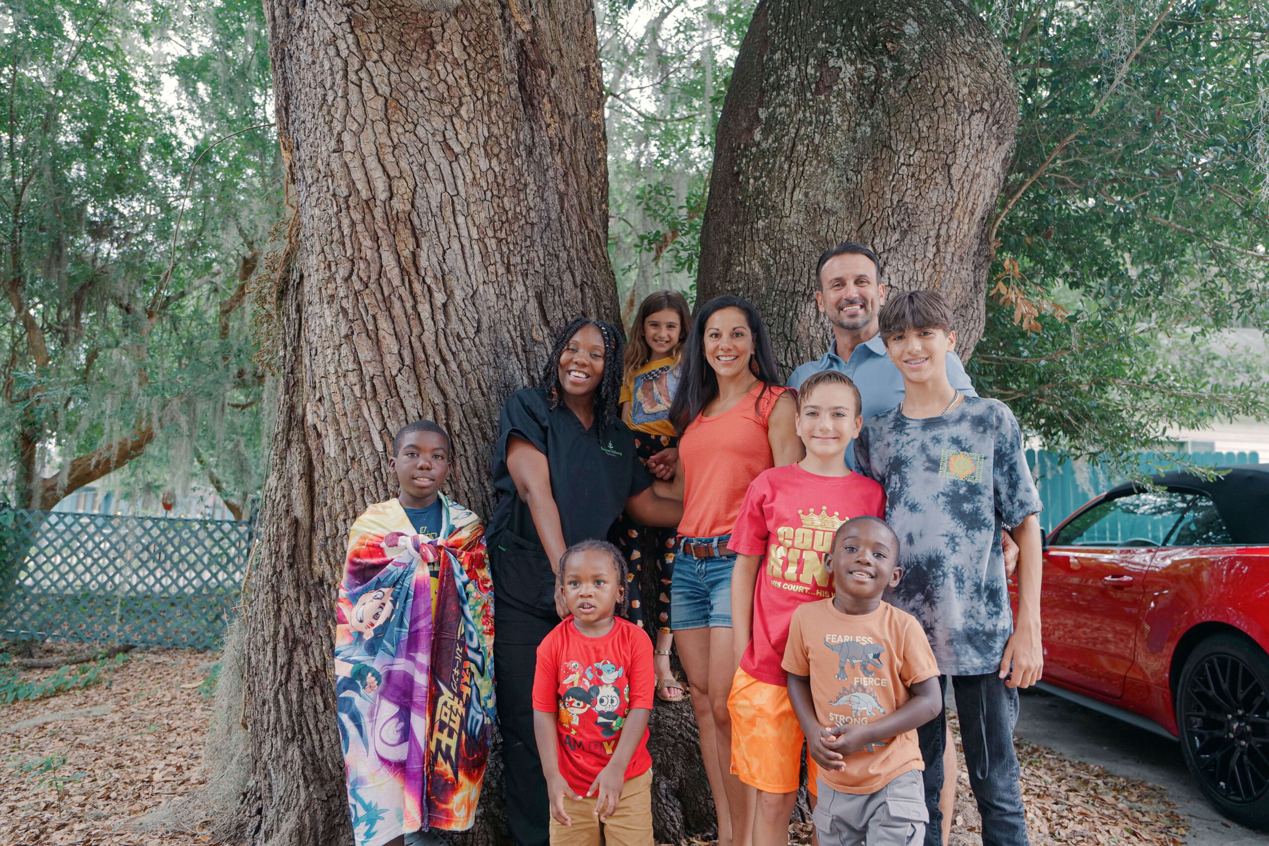 Two families gather in front of two enormous tree trunks