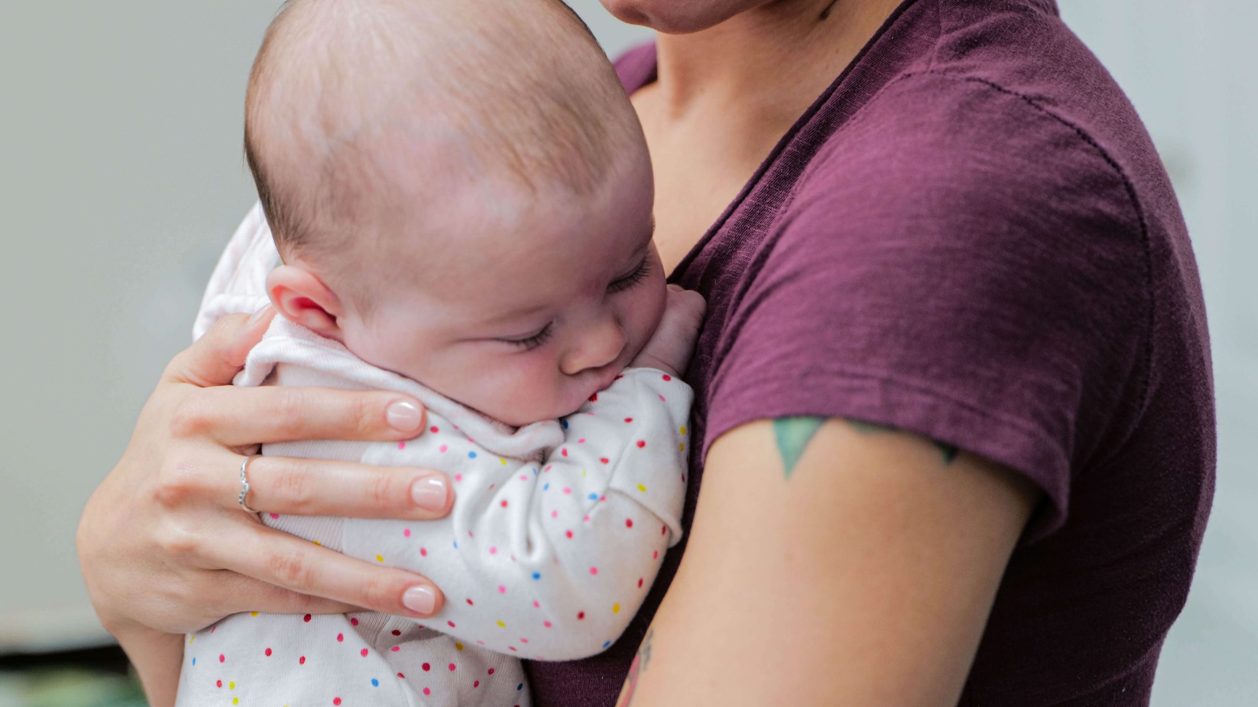 Close up of a baby in a woman's arms