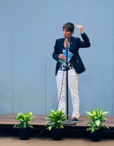 Cindy Spray speaks at a microphone on stage