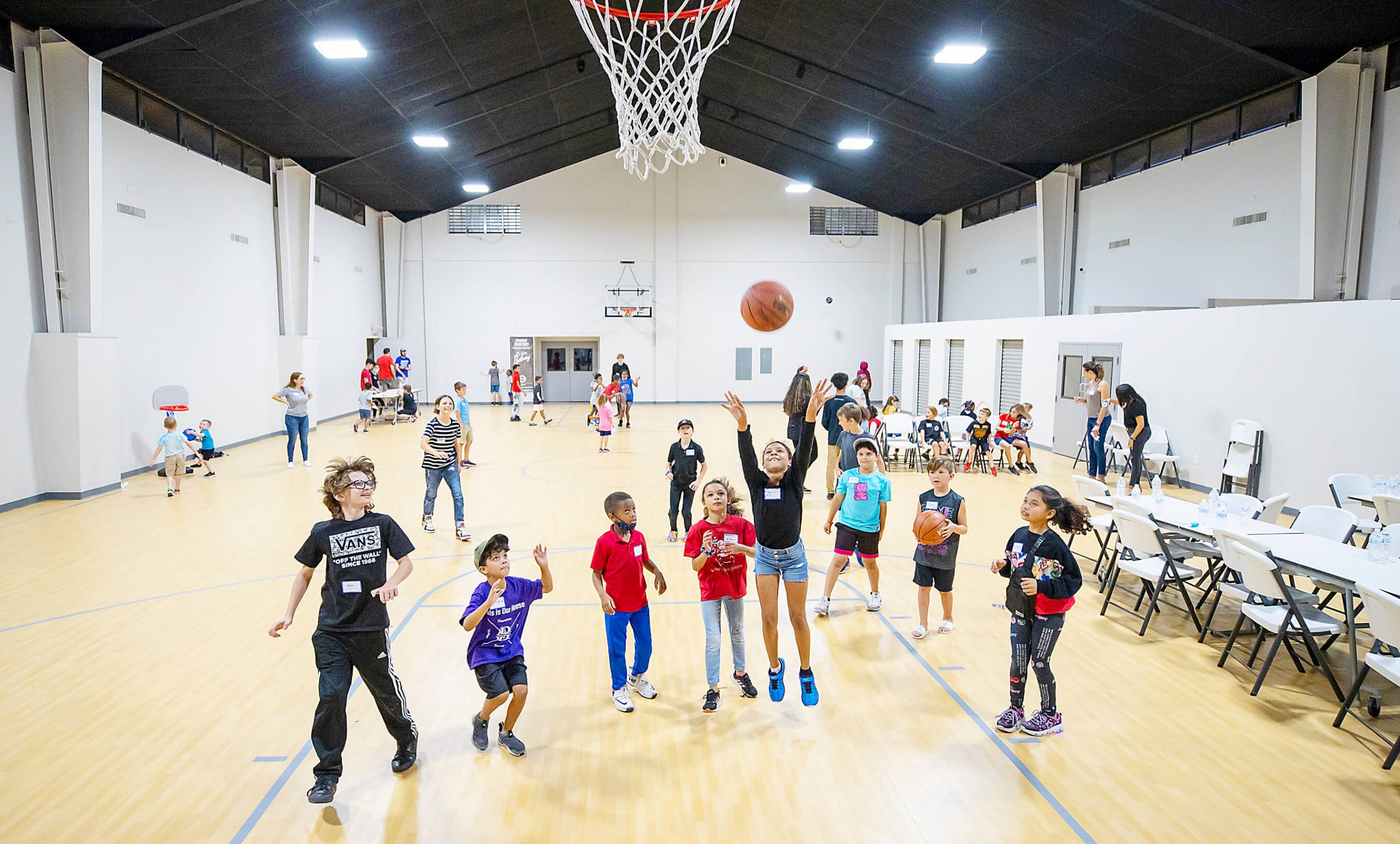 Children play basketball in a church gymnasium
