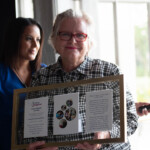 Woman holds framed award