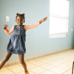 Young girl dances in a nearly empty room